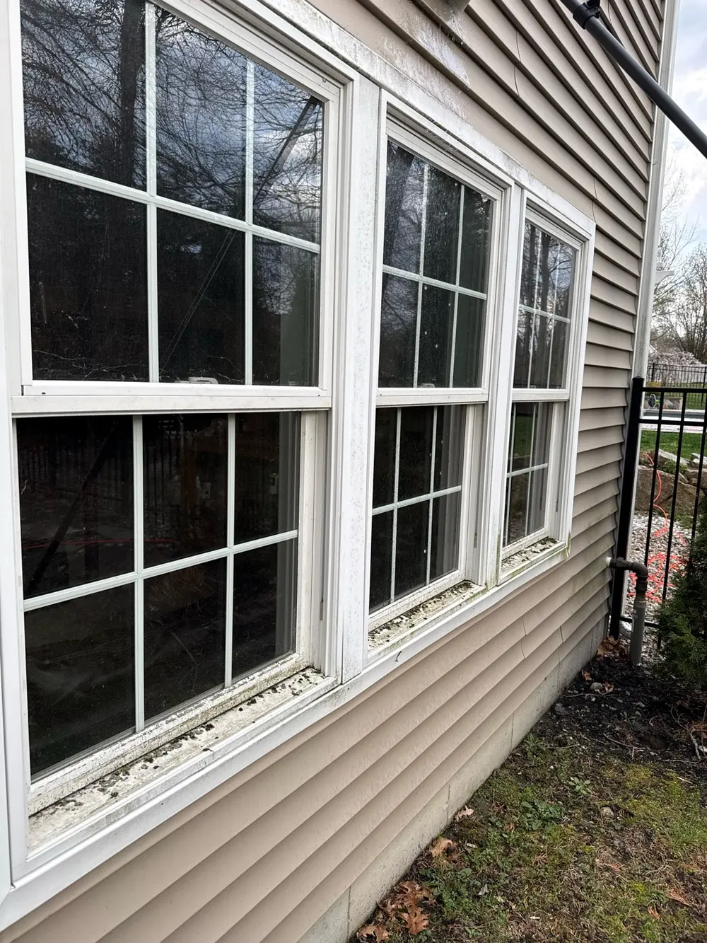 Before: white double-hung windows with cloudy glass and sills full of dirt and debris